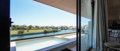 A modern balcony with a view of a river and distant buildings.
