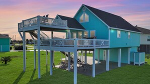 A two-story house with a balcony and a covered patio area.