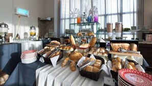 A breakfast buffet with various breads, pastries, and beverages. - NATAL PLAZA - Suite on the 19th floor (Vila de Ponta Negra Natal)