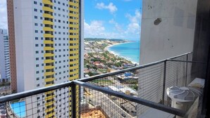 A high-rise building with balconies overlooking a coastal area with a beach and ocean. - NATAL PLAZA - Suite on the 19th floor (Vila de Ponta Negra Natal)