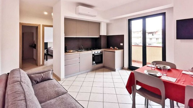 Un apartamento moderno con cocina, comedor y sala de estar con sofá.