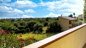 Un balcón con vista a una zona residencial, con casas y vegetación.