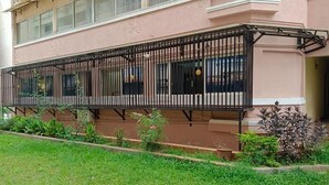 A building with a balcony and a garden area. - SS LUMINA GUEST HOUSE (Bengaluru)