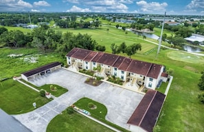 Stunning single-story building with a central entrance and two wings, set amidst a beautifully manicured lawn and scenic surroundings.