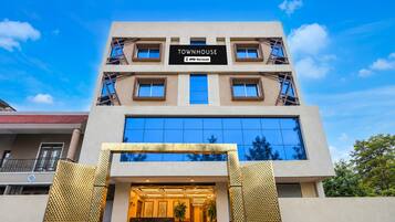 A modern building with a sign reading 'TOWNHOUSE' and 'oyo-serviced' indicating a serviced apartment complex.