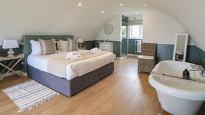 Una camera da letto con un letto grande, un bagno con una vasca e una doccia.