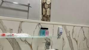 A bathroom with a white sink, a mirror, and a marble backsplash. - Premium 777 (Tashkent)