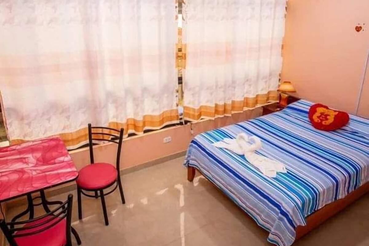 A small, cozy room with a single bed, a desk, and a chair.
