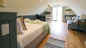 A cozy, well-lit room with a bed, a sofa, and a dining area. - Creags (Oban)