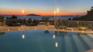 A swimming pool with a sunset view, surrounded by lounge chairs and potted plants. - La Canostra Capri - luxury villa (Anacapri)