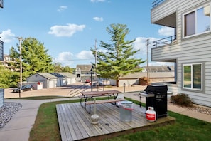 A residential outdoor area with a wooden deck, barbecue grill, and picnic table. - Pine Needle 506 at Lighthouse Cove (Wisconsin Dells)