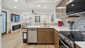 A modern kitchen with a dishwasher, stove, and a large island. - Pine Needle 506 at Lighthouse Cove (Wisconsin Dells)
