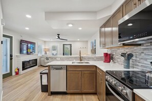 A modern kitchen with a dishwasher, stove, and a large island.