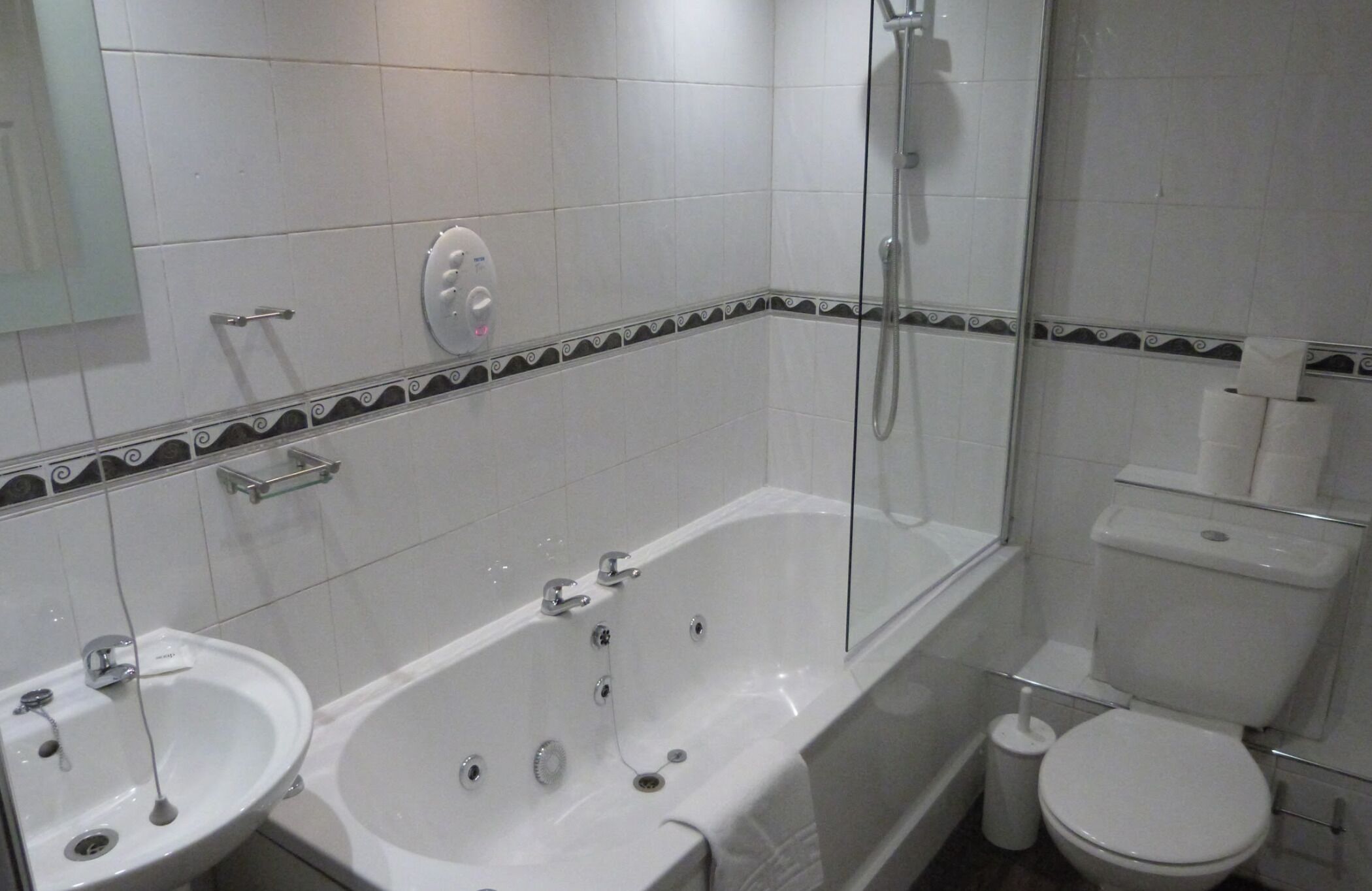 A bathroom with a bathtub, two sinks, a toilet, and a shower.