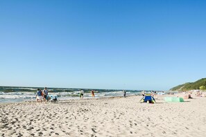 A sandy beach with people, a tent, and a clear sky. - Studio in Miedzywodzie Near Baltic Beach (Dziwnów)