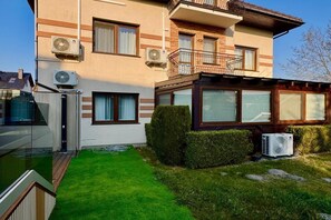 A two-story residential building with air conditioning units, a balcony, and a well-maintained lawn. - Studio in Miedzywodzie Near Baltic Beach (Dziwnów)