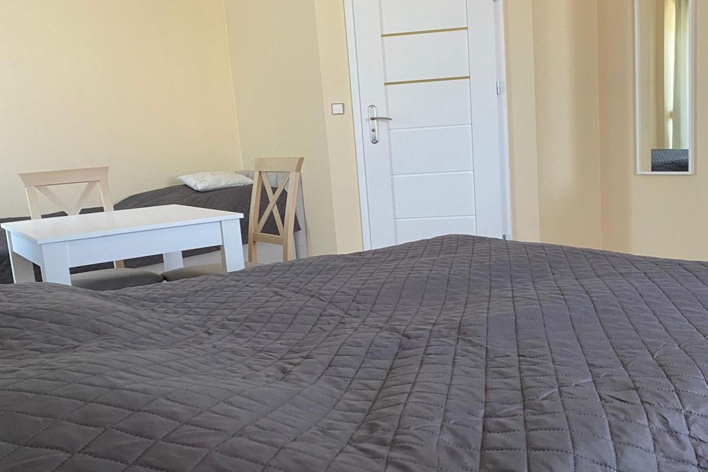 A room with a bed, a desk, and a chair.
