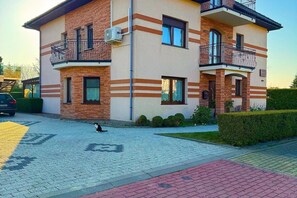 A two-story building with a brick facade, multiple windows, and balconies. - Studio in Miedzywodzie Near Baltic Beach (Dziwnów)