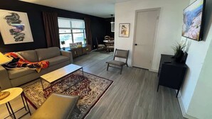 Un salon moderne avec un canapé, une table basse et un tapis à motifs.