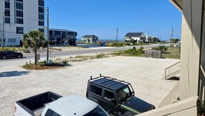 Une route côtière bordée d’un pick-up blanc et d’un véhicule utilitaire vert, tous deux garés sur le bord de la route.