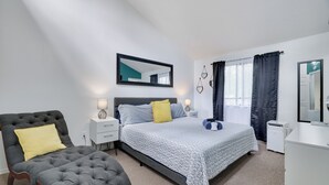 A bedroom with a bed, a chair, a bedside table, a lamp, and a mirror. - Spacious & Charming Poconos Pine Hideaway (Tobyhanna)