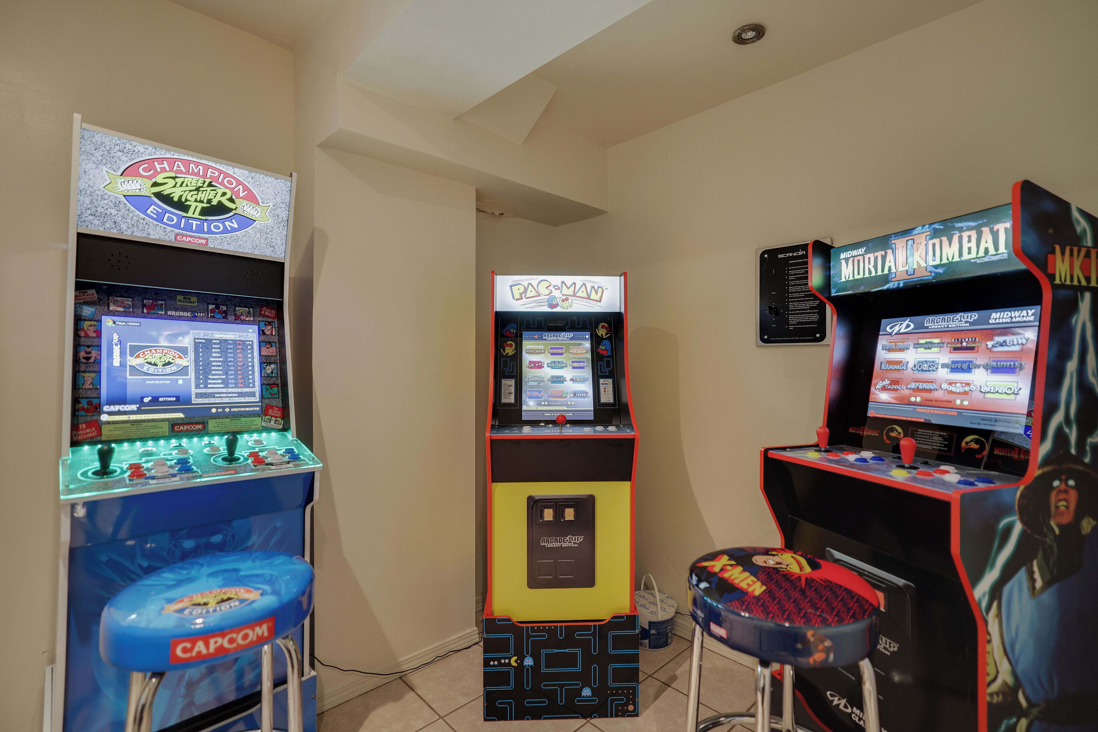 A room with arcade machines including Pac-Man, Street Fighter II, and Mortal Kombat.