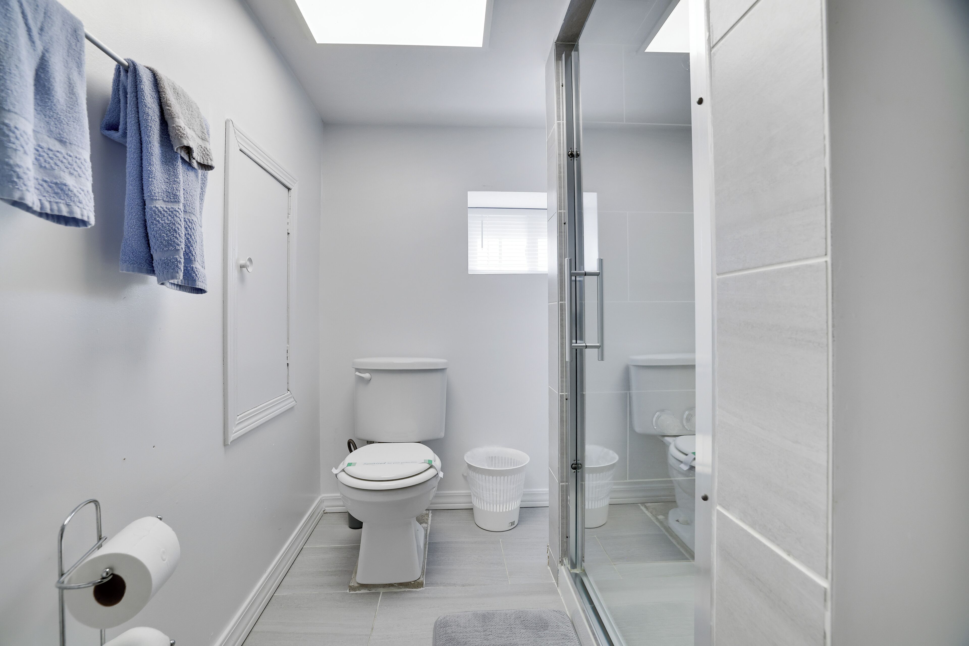 A modern bathroom with a toilet, bidet, and glass shower enclosure.