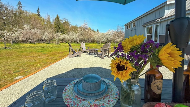 Una mesa colocada al aire libre con vistas a un jardín y una casa al fondo.
