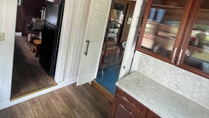 Een keuken met houten kastjes, een koelkast en een aanrecht.