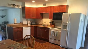 A kitchen with wooden cabinets, a dishwasher, a stove, and a refrigerator.