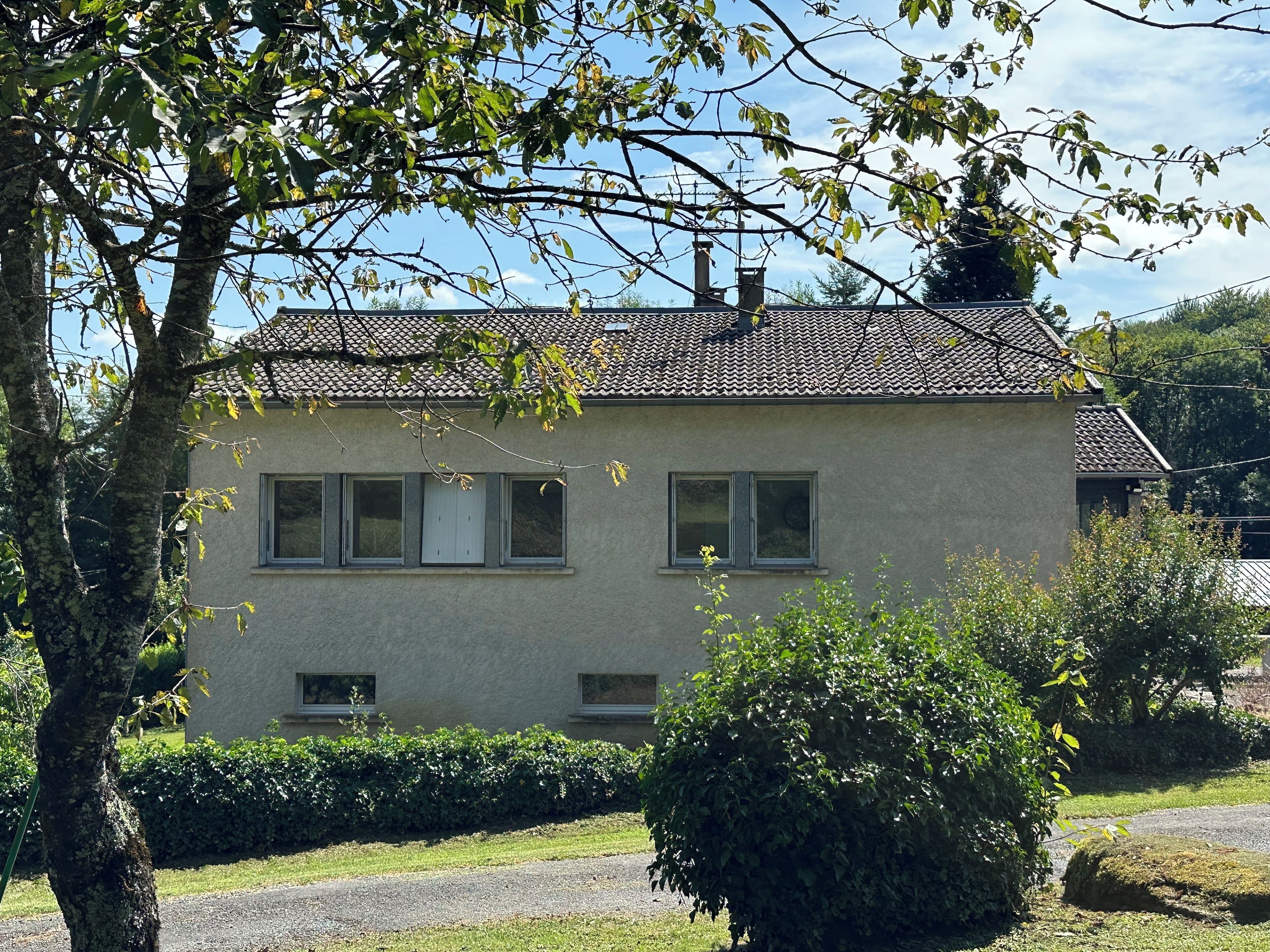 A two-story building with a tiled roof, multiple windows, and a well-maintained garden.