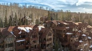 A lodge with multiple wooden buildings, stone foundations, and snow-covered roofs. - 10 Trails Edge-Curate Telluride, Ski-in/out, Walk to Gondola, Market, Hot Tub (Mountain Village)