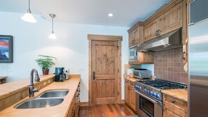 A modern kitchen with wooden cabinets, stainless steel appliances, and a double sink.