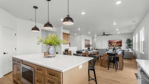 A modern kitchen with a central island, wooden cabinetry, and pendant lighting. - [The Grandview] Pool, Pickleball, Hot Tub, Views (Page)