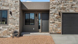 A modern house with a stone facade, a driveway, and a sign that reads "Grandview." - [The Grandview] Pool, Pickleball, Hot Tub, Views (Page)