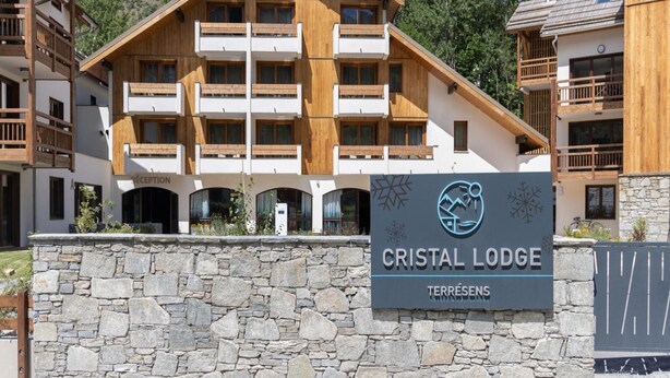 A multi-story hotel with a stone facade and wooden balconies, named 'Cristal Lodge'. - Apartment in Chantemerle Near Serre-chevalier (Saint-Chaffrey)