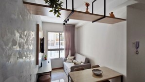 Una sala de estar moderna con un sofá, una mesa de comedor y una zona de cocina.