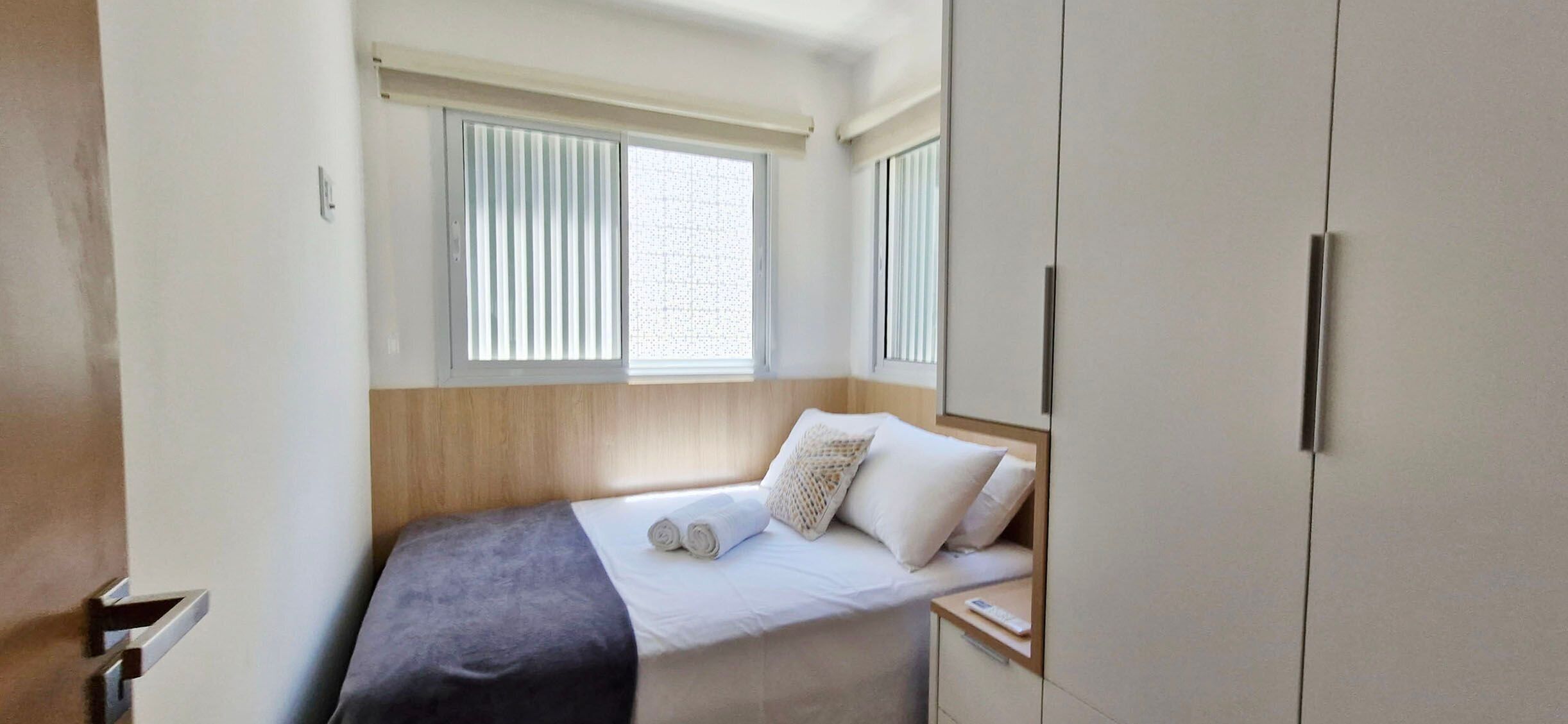 Une chambre à coucher avec un lit, une fenêtre et une armoire.