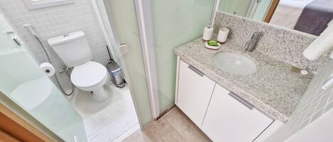 A modern bathroom with a toilet, bidet, and sink.
