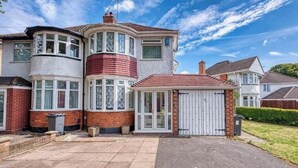 A two-story house with a bay window, a garage, and a small front porch. - 3-bedroom apartment in awesome Birmingham with WiFi (Birmingham)