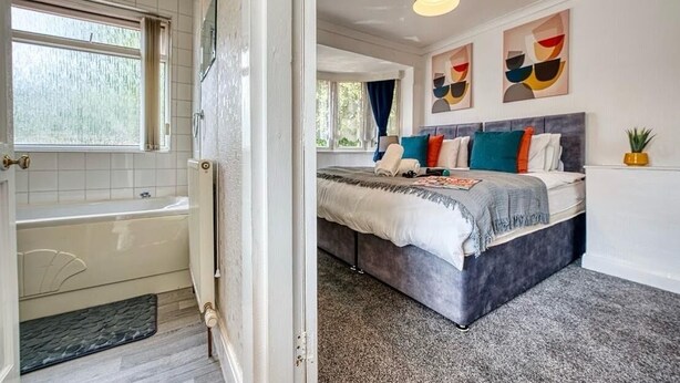 A bedroom with a bed, a window, and a bathtub. - 3-bedroom apartment in awesome Birmingham with WiFi (Birmingham)