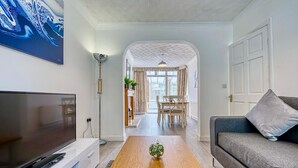 A living room with a flat-screen TV, a grey sofa, and a wooden coffee table. - 3-bedroom apartment in awesome Birmingham with WiFi (Birmingham)