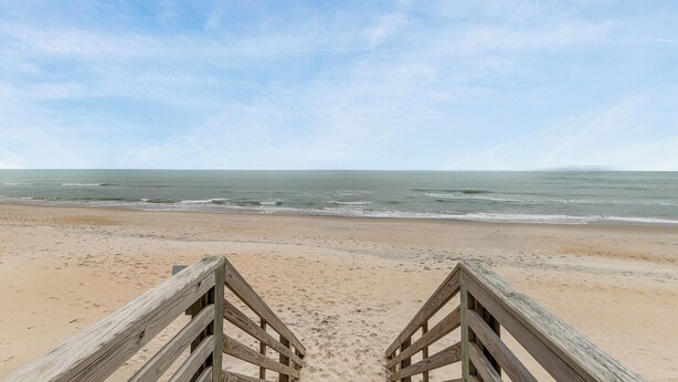 A wooden boardwalk leading to a sandy beach with the ocean in the background. - Charming 2-bedroom condo with fitness room, WiFi in awesome Surf City (Surf City)