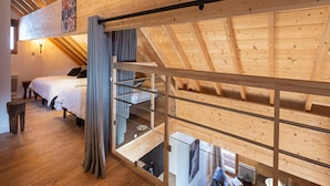 A loft-style bedroom with a sloped ceiling, wooden beams, and a bunk bed. - Apartment in Vaujany Near Alpe D'huez (Vaujany)