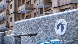 A multi-story wooden building with balconies, a stone wall, and a sign for 'Daddy Pool'. - Apartment in Aime-la-plagne Near Fornelet Lift (Aime-la-Plagne)