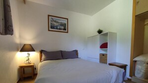 A bedroom with a bed, a bedside table with a lamp, a wardrobe, and a painting on the wall. - 200m from ski slopes, view ski slopes, swimming pool, sauna, tv, ski locker, 35m², Les Orres (Les Orres)