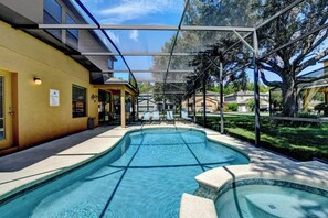 A swimming pool with a covered area, lounge chairs, and a sign indicating a pool area.