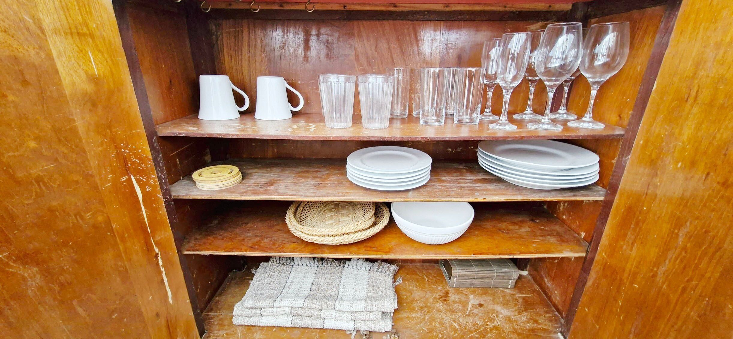 A wooden shelf unit with various glassware and plates.