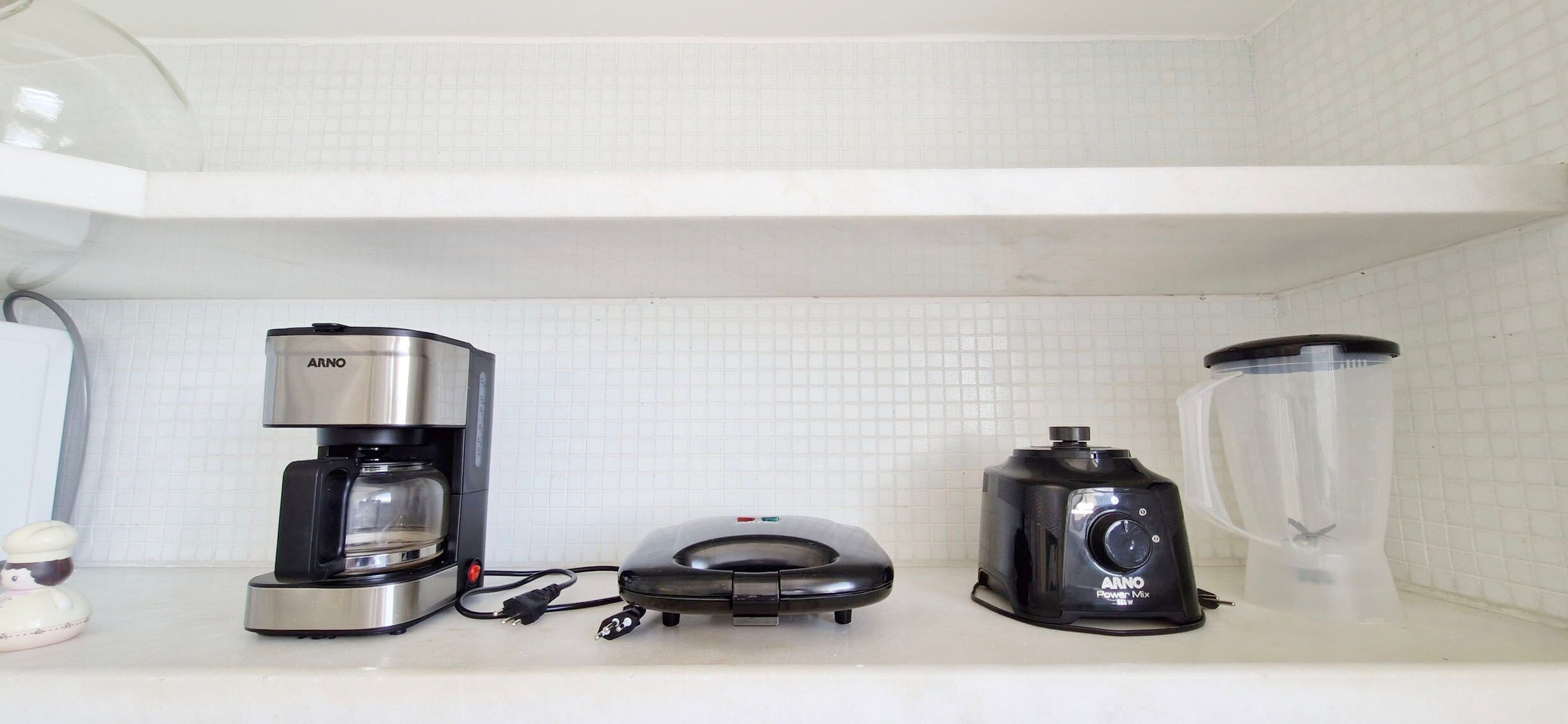 Un plan de travail de cuisine avec une machine à café, un mixeur et une multiprise.