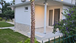 A modern two-story house with a white exterior, a covered porch, and a well-maintained lawn. - VILLA OLINDA 4 BED with huge garden (Serik)
